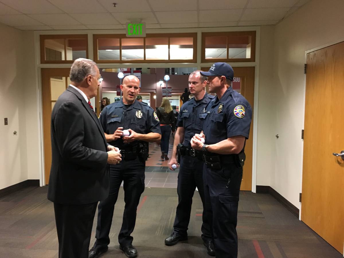 Councilman Don Marchant speaks with Cedar City police officers at Thursday night's debate. 
