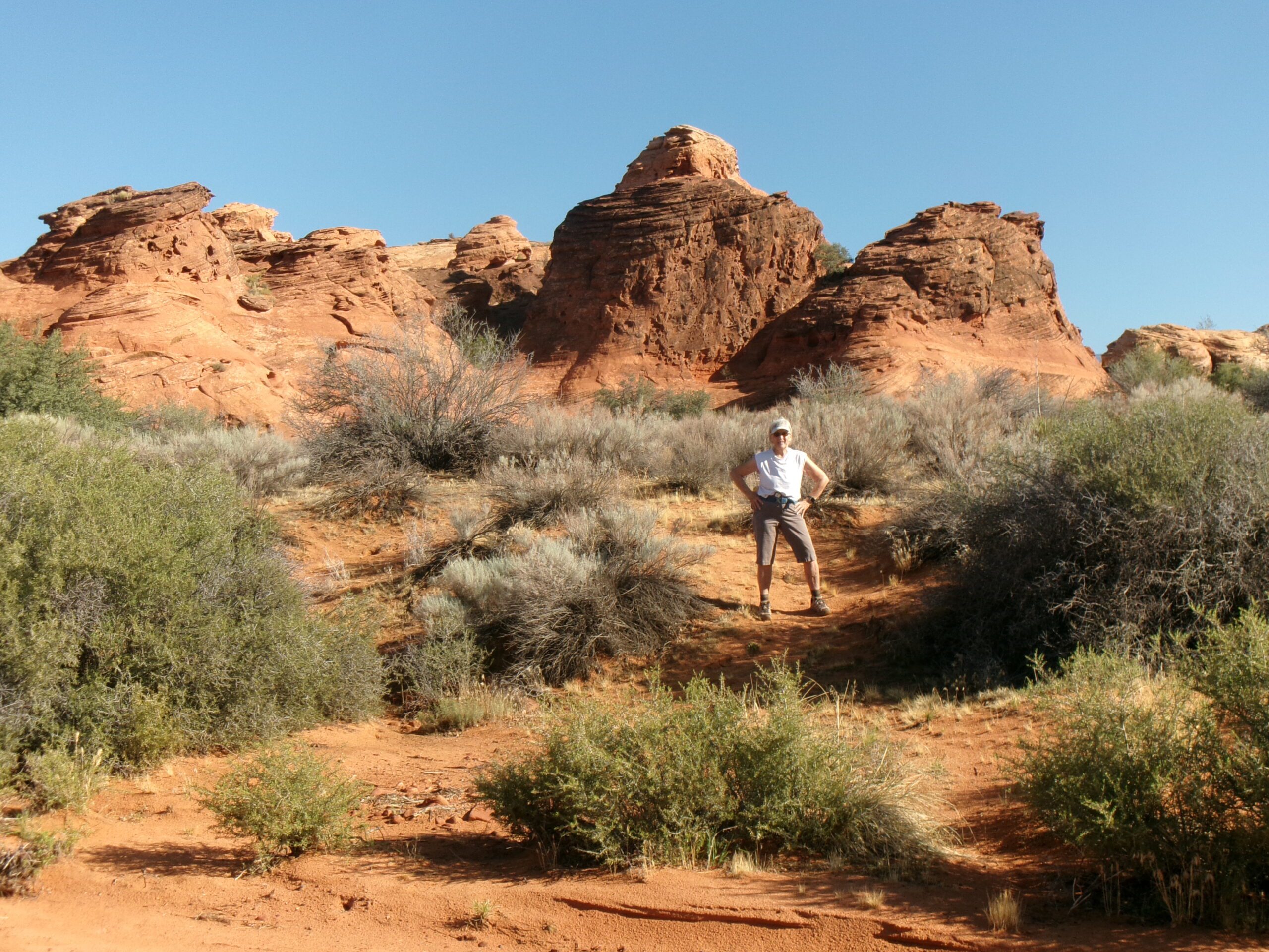  Deb in front of large red rock formation, Spanish Wash Trail, August 2026. Photo by Tom Garrison